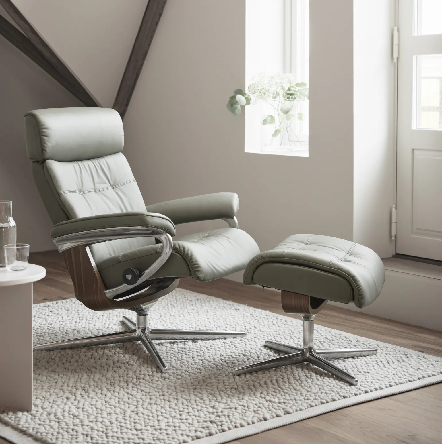 With a nod to mid-century design, the Stressless Erik echoes a classic silhouette into a contemporary, deeply cushioned, luxury recliner with an ergonomic fit. Combining vintage charm with a touch of modernity, the premium detailing of the recliner is highlighted by a supple top cushion with double stitching and the adjustable headrest can add an additional 10 cm to the back height if required.

On the inside, you will find all the usual Innovative Stressless comfort technology such as the signature Stressless Plus™ and Glide™ systems, which automatically adjust to your body’s movement for continuous support.

Available in Small, Medium, and Large sizes, each chair has a matching footstool available and is fully customisable with a wide range of luxurious leathers, soft fabrics, and bases in various wood finishes to perfectly match your interior style.
